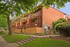 a large brick building with a lawn and trees