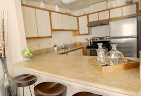 A kitchen with a countertop and stools.