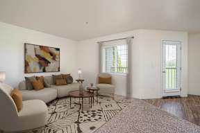 A living room with a white couch, a coffee table, and a painting on the wall.