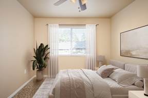 A bedroom with a large bed and a ceiling fan.