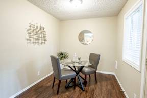 A dining room with a table and chairs.
