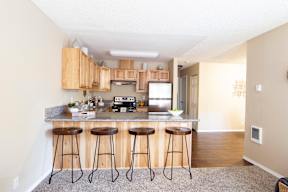 A kitchen with a bar stool in front of it.