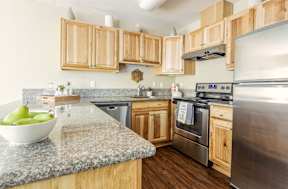 A kitchen with wooden cabinets and granite countertops.