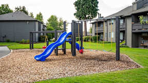 A playground with a blue slide and a red slide.
