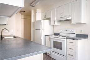 A kitchen with white appliances and cabinets.