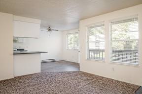 A room with a ceiling fan and a window with blinds.
