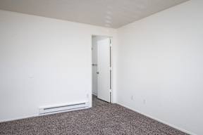 A room with a carpeted floor and a white door.