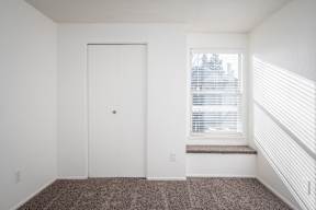 A room with a white door and a window with blinds.