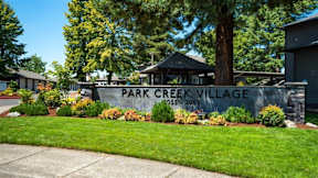 A sign that says Park Creek Village stands in front of some houses.