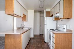 A kitchen with white appliances and wooden cabinets.