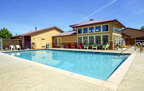 A large swimming pool in front of a house.