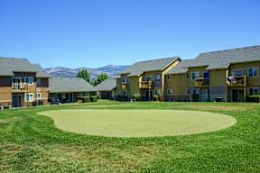 A golf course surrounded by buildings.