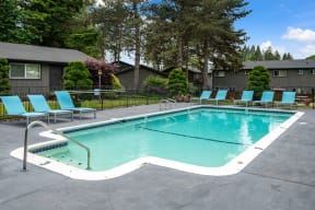 a swimming pool with blue chairs and a building in the background