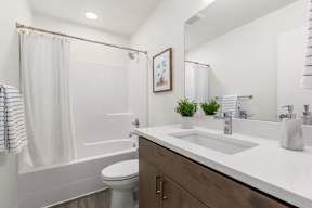 A white bathroom with a toilet, sink, and shower.