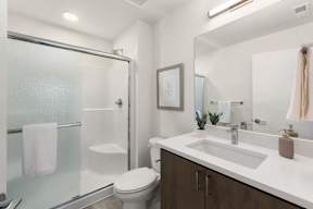 A white toilet sits next to a white sink in a modern bathroom.