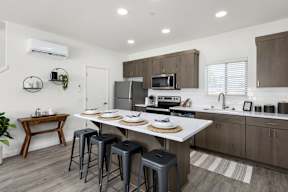 A kitchen with a white countertop and brown cabinets.