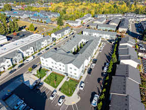 A parking lot with cars and apartment buildings in the background.