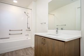 A white sink is on a counter in a bathroom.