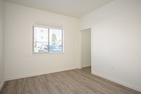 A room with a window and wooden flooring.