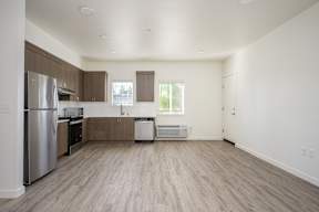 A kitchen with a refrigerator, dishwasher, and oven.
