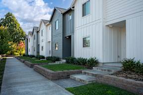 A row of modern houses with white and grey exteriors.