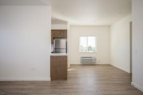 A kitchen with a refrigerator and a window.