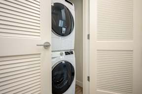 A white washing machine is in a small room.