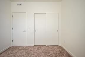 A room with two doors and a carpeted floor.