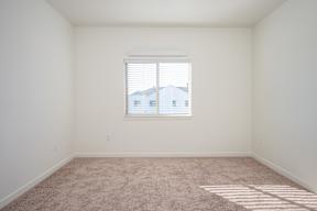 A room with a window and carpeted floor.