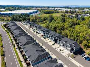 A row of houses with a road in front of them.