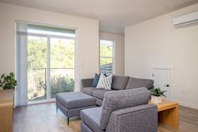 A living room with a grey couch and a wooden coffee table.
