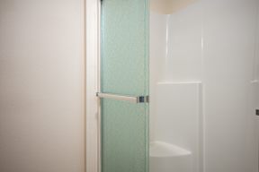 A white door with a silver handle and a glass panel.