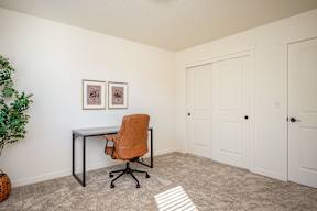 A room with a desk and an orange chair.