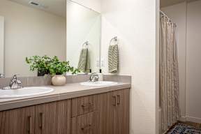 A bathroom with two sinks and a shower curtain.