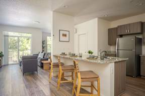 A kitchen with a table and chairs in front of it.