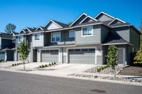 A row of houses with grey and blue siding.
