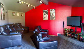 A living room with a red wall and a television.