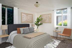 A bedroom with a bed, chair, and two lamps.