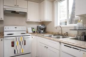 A white stove with a checkered towel on it.