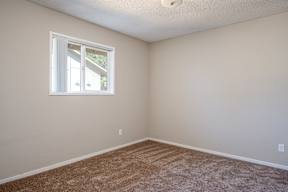 A room with a window and carpeted floor.