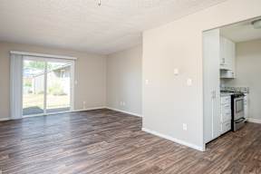 A kitchen area with a refrigerator, oven, and cabinets.