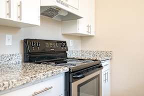 A black stove top oven sitting on a granite counter.