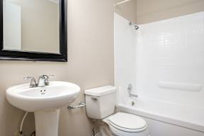 A bathroom with a sink, toilet and bathtub.