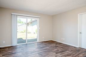 A room with a sliding glass door leading to a backyard.