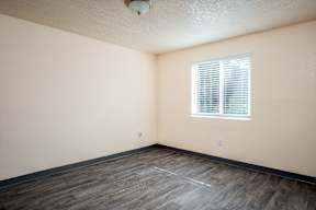 A room with a window and wooden flooring.