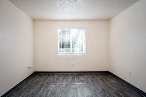 A room with a window and wooden floor.
