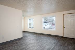 A room with a white door and a window with blinds.