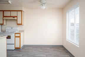 A kitchen with a white oven and wooden cabinets.