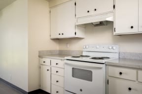 a kitchen with white appliances and white cabinets and counter tops