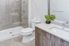 A white toilet sits next to a walk-in shower in a bathroom at The Anthem at Square 10 Apartments, Connecticut, 06510